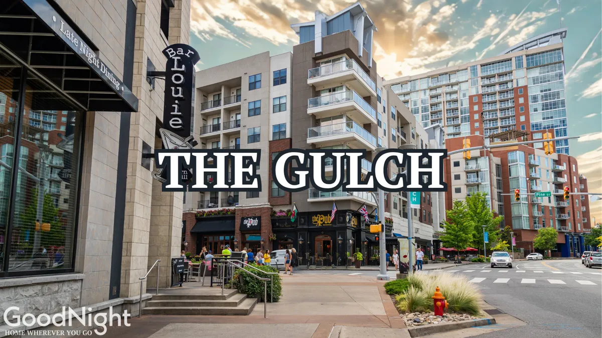 Bar Louie signage stands out in a bustling area surrounded by modern apartment buildings, lush landscaping, and pedestrian activity. The scene features outdoor cafes, street furniture, and a lively crowd, representing the neighborhood's social and networking opportunities.