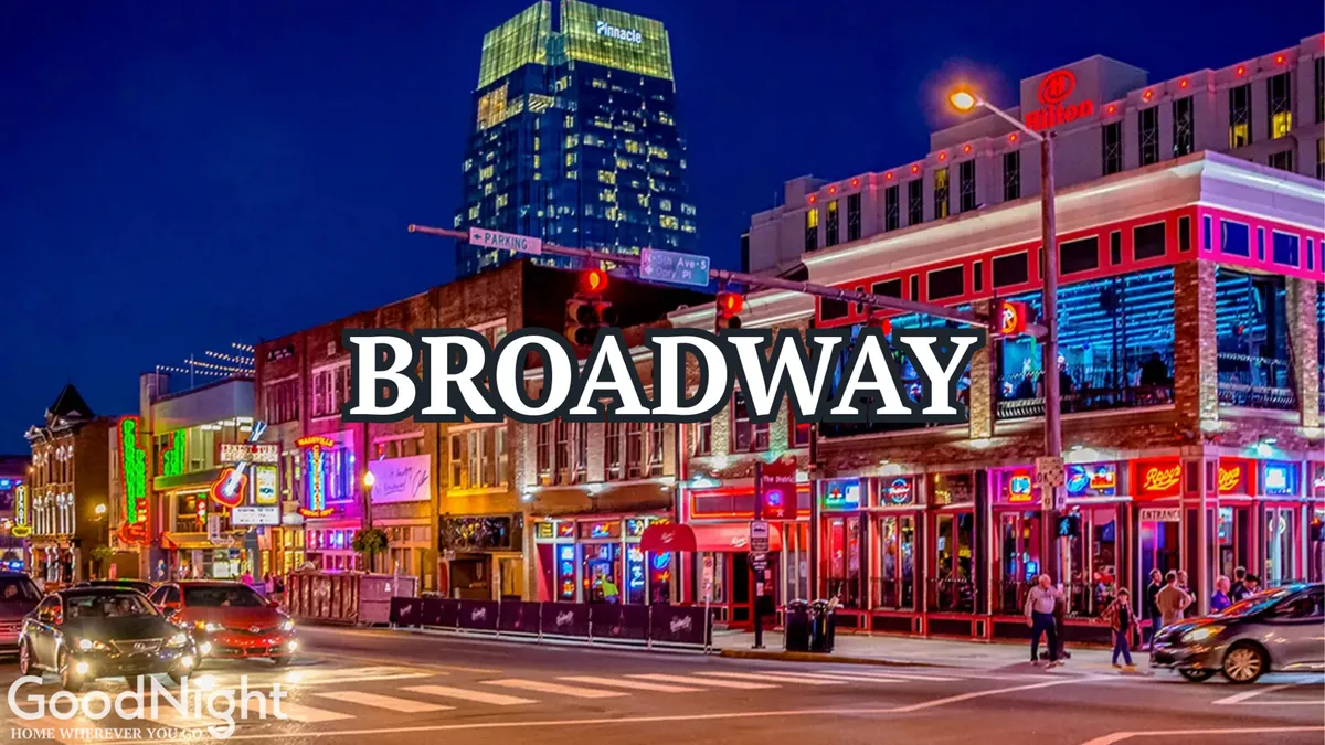 This image captures a vibrant street scene in downtown Nashville, featuring colorful neon signs, lively crowds, and distinctive building facades. The festive atmosphere hints at the city's famous nightlife and abundance of live music venues, encapsulating the energy of Broadway and the core of Music City’s entertainment district.